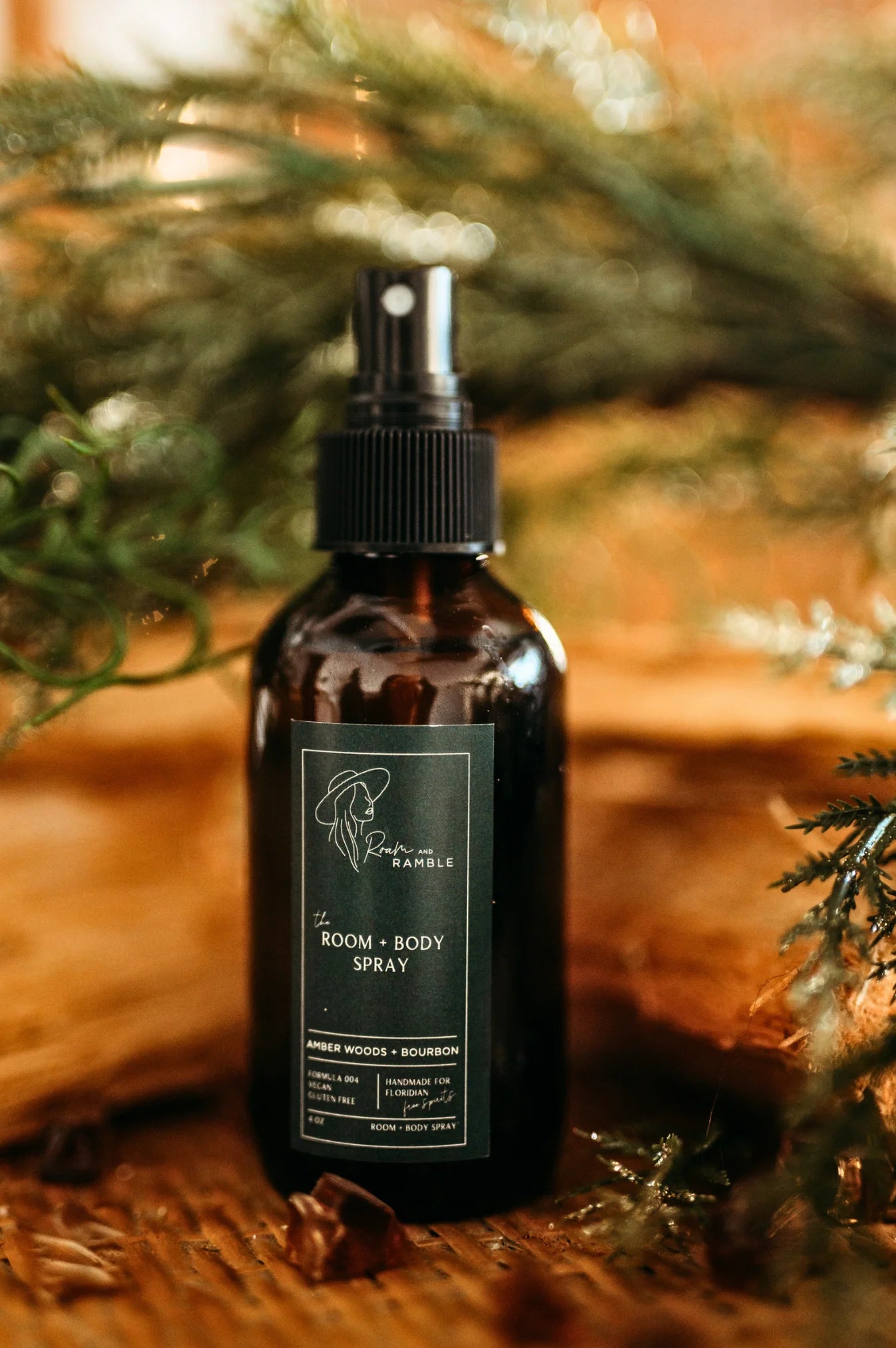 Brown spray bottle with a label on a wooden surface with greenery in the background