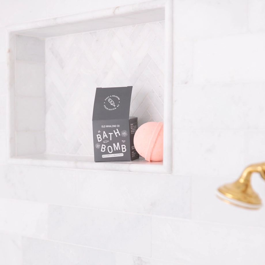 Bath bomb with packaging on a white bathtub