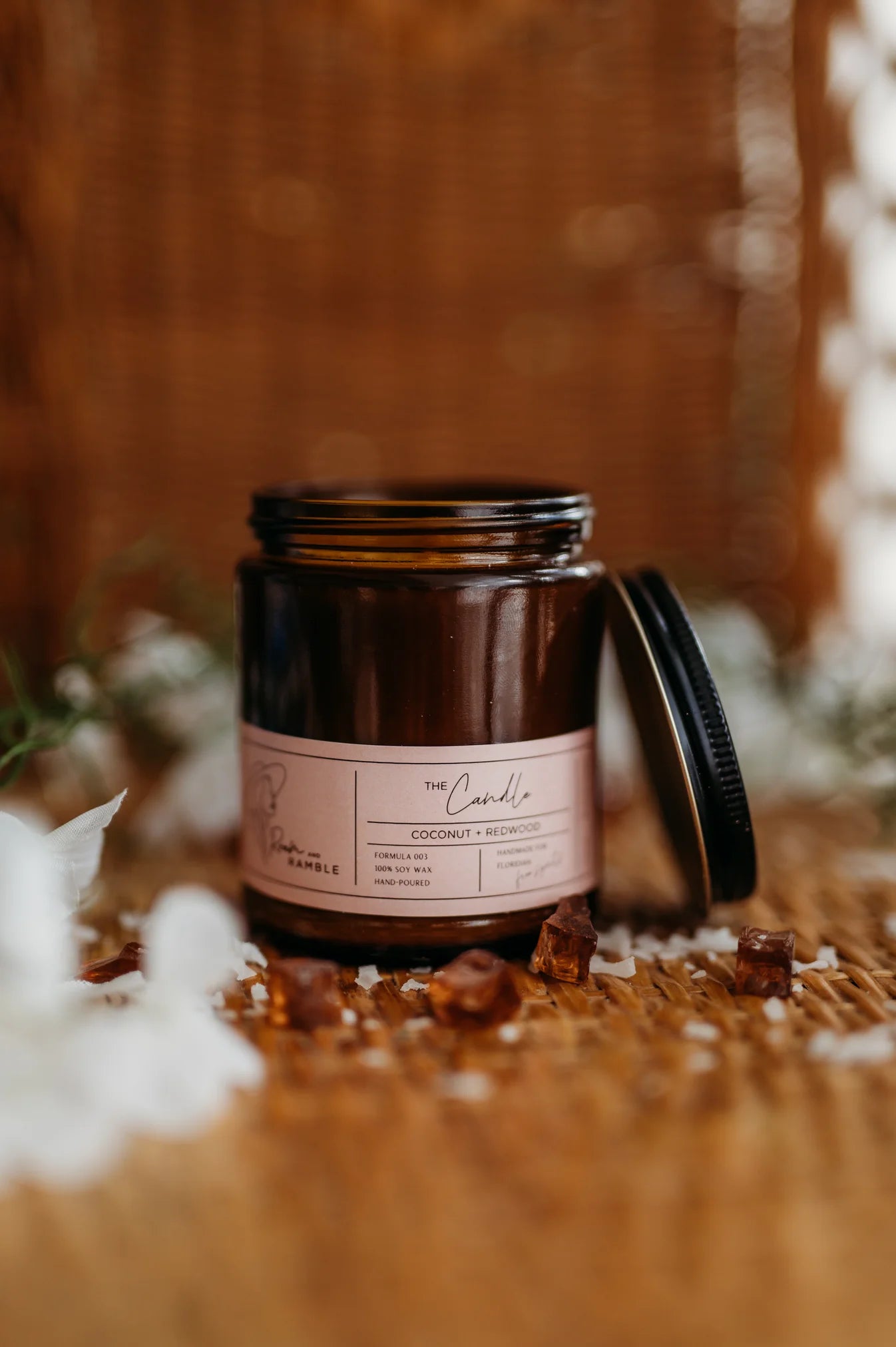 Candle jar with a label on a wooden surface with decorative elements