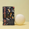 Kale Meleod body moisturizer and natural insect repellant packaging with a white stone on a yellow background