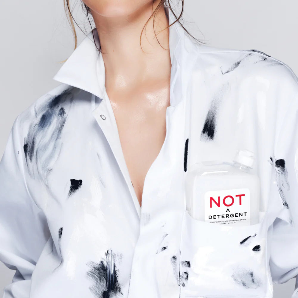 Juliette Has a Gun Not A Detergent 500mL, available at Rafa Natural. Model wearing stained shirt, with the detergent in the breast pocket.