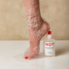 Juliette Has a Gun Not A Shower Gel 250mL, available at Rafa Natural. Foot with red nail polish, and soap suds shown next to the product.