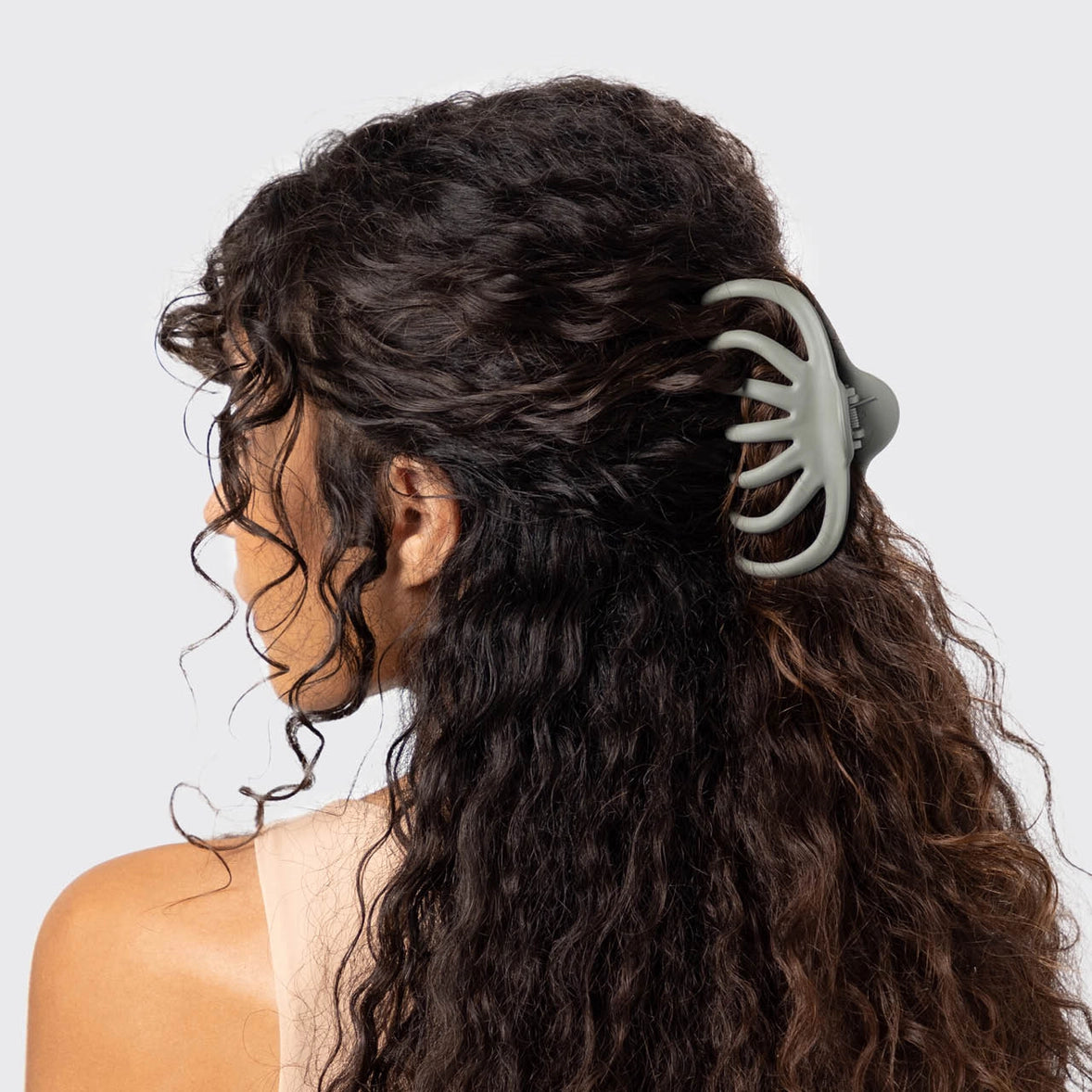Woman wearing light green octopus claw clip.