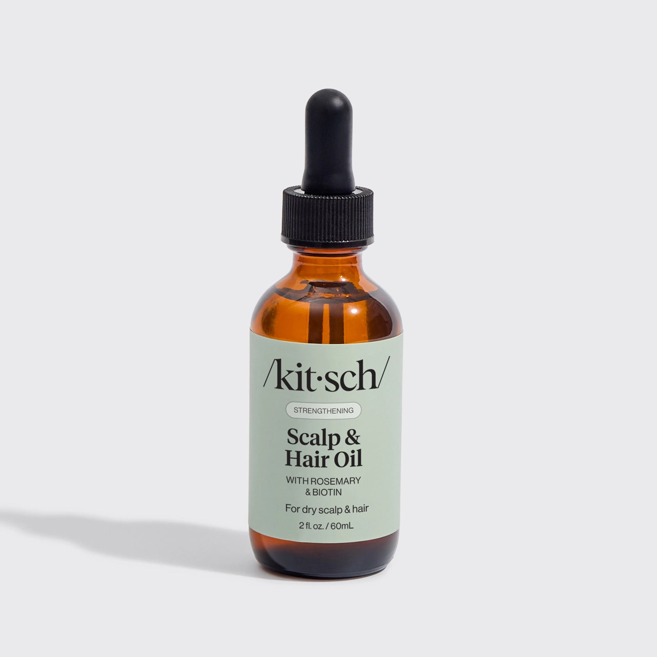 Kitsch scalp and hair oil bottle with dropper on a light gray background