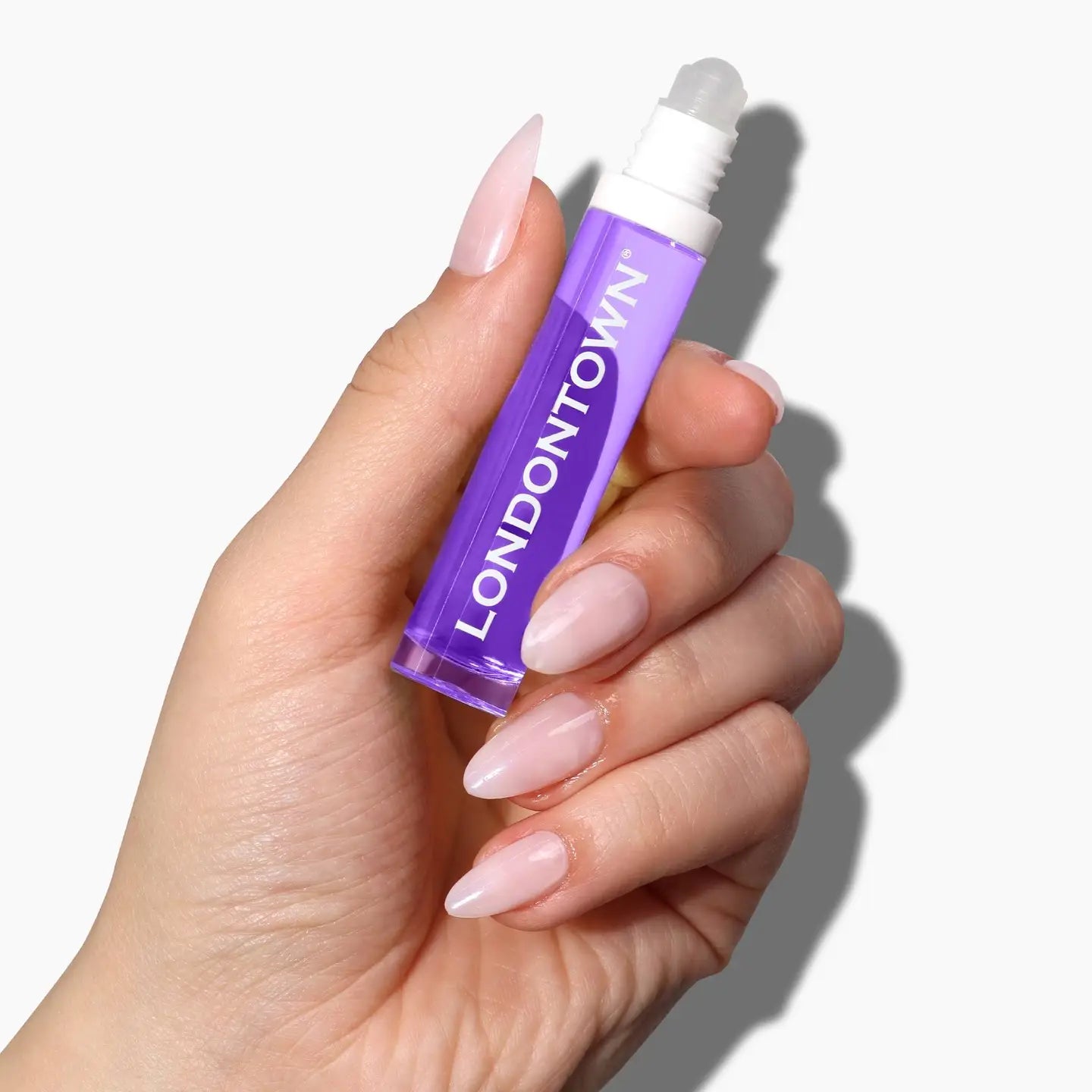 Purple Lavender Nighttime Cuticle Quench bottle held up showing product against white background with manicured nails