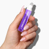 Purple Lavender Nighttime Cuticle Quench bottle held up showing product against white background with manicured nails