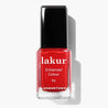 Red nail polish bottle with black cap on a white background
