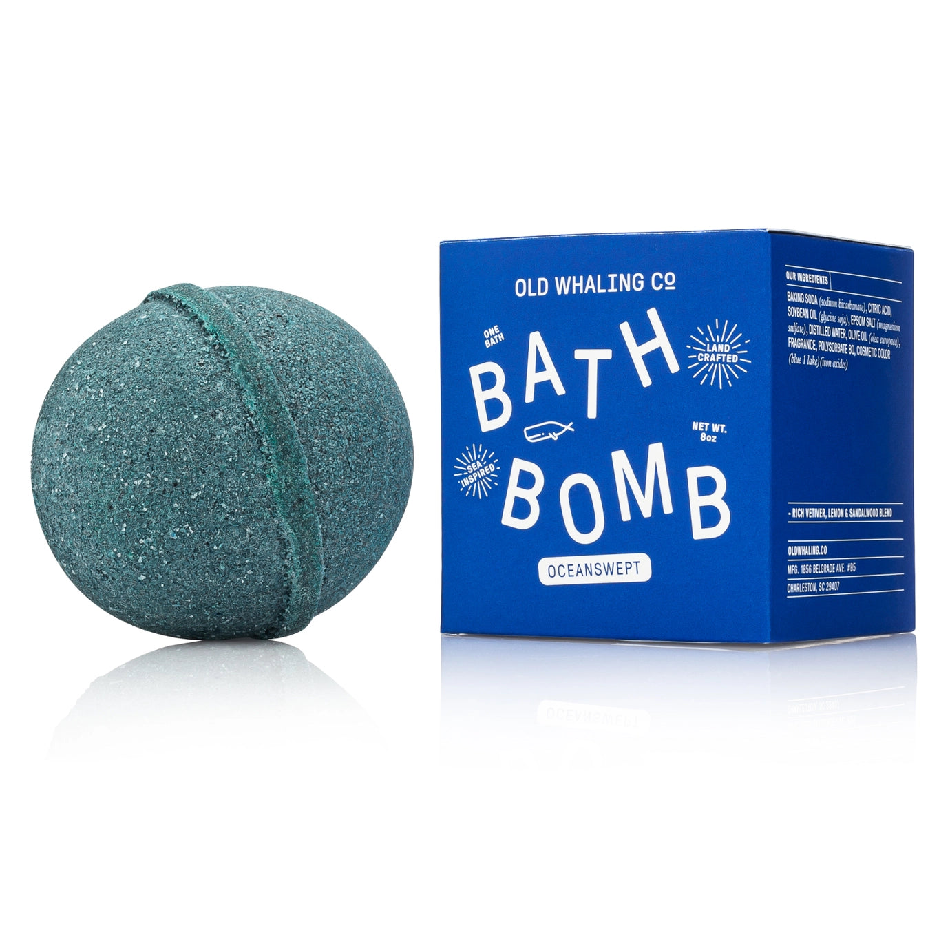 Green bath bomb next to its blue packaging on a white background
