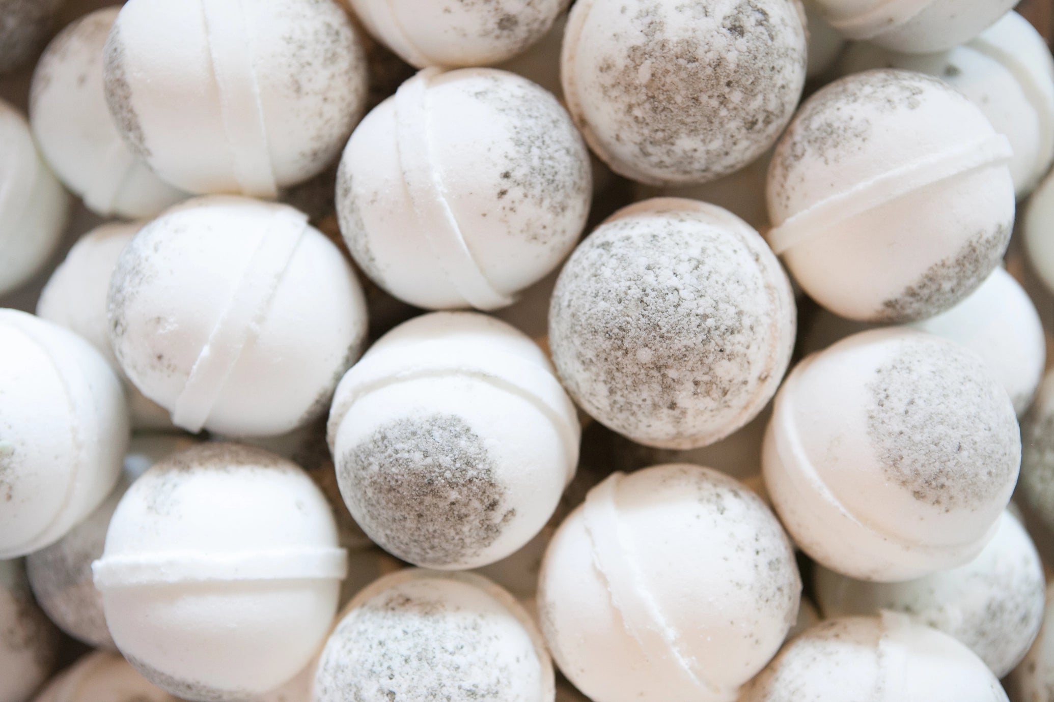 Close-up of white bath bombs with specks on a white background