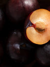 Close-up of a halved plum with dark purple skin