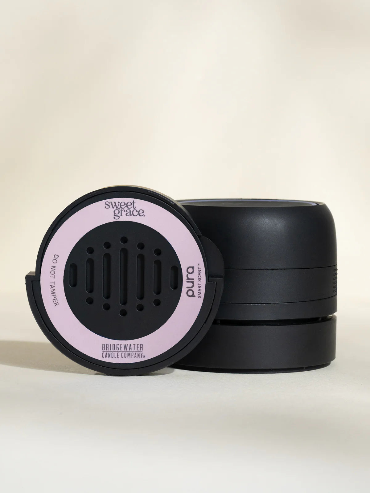 Black container with pink label on a beige background