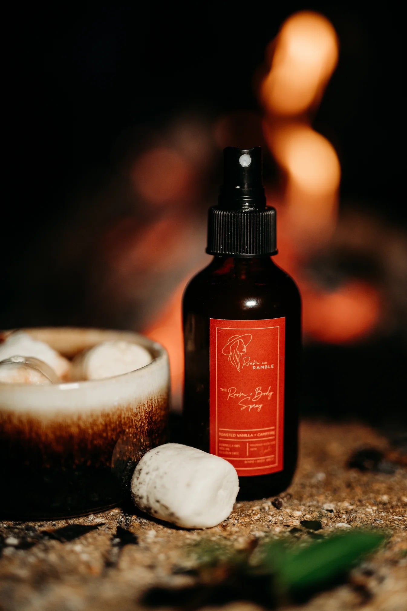 Black spray bottle with red label on a stone surface with a warm glow in the background