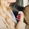 Person holding a touchless hand sanitizer dispenser in a car.
