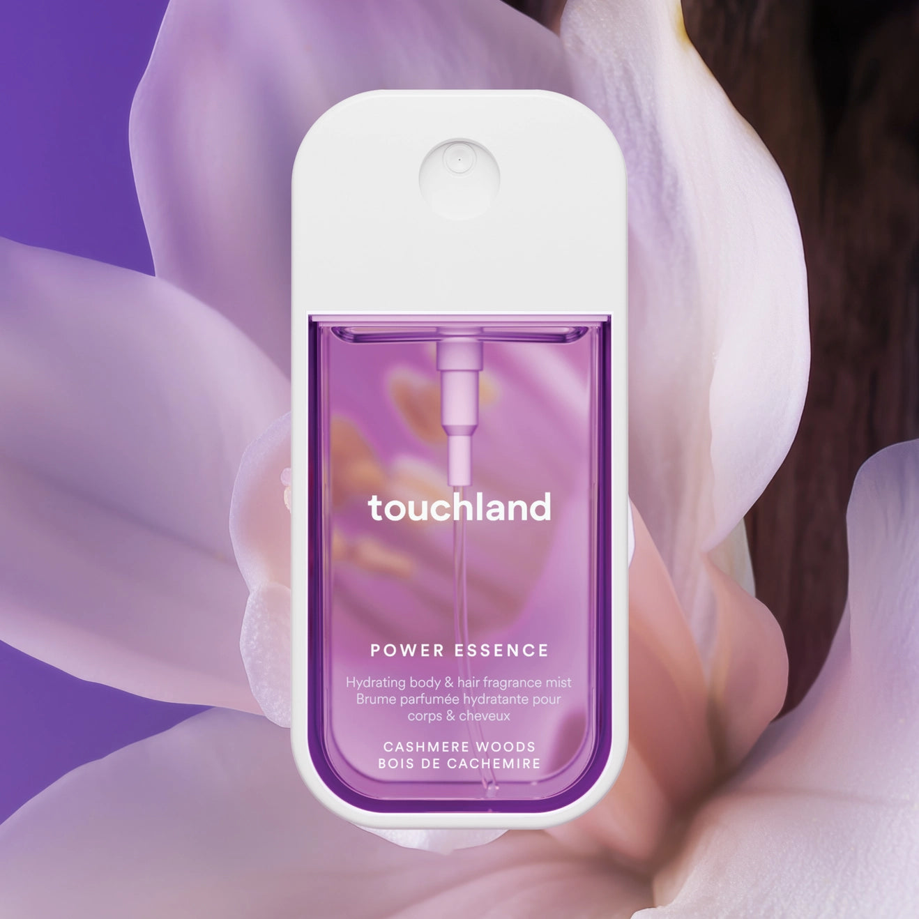 Touchland power essence product held against a soft floral background