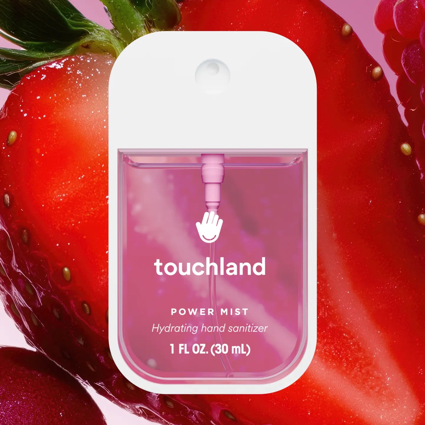 Touchland Berry Bliss Power Mist, in front of a large, halved strawberry.