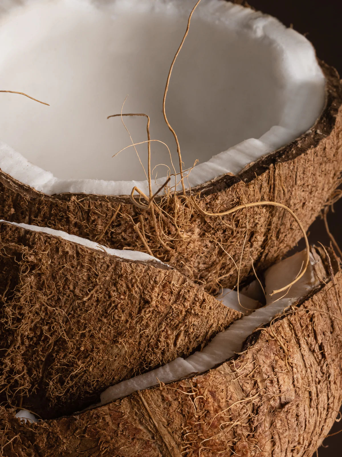 Close-up of a split coconut with white flesh and brown outer shell.