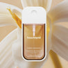 Touchland Power Essence bottle with a floral background